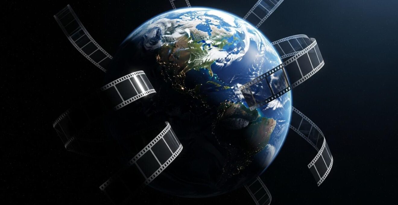 Photo symbolique d’un globe terrestre partiellement éclairé, entouré de pellicules de films